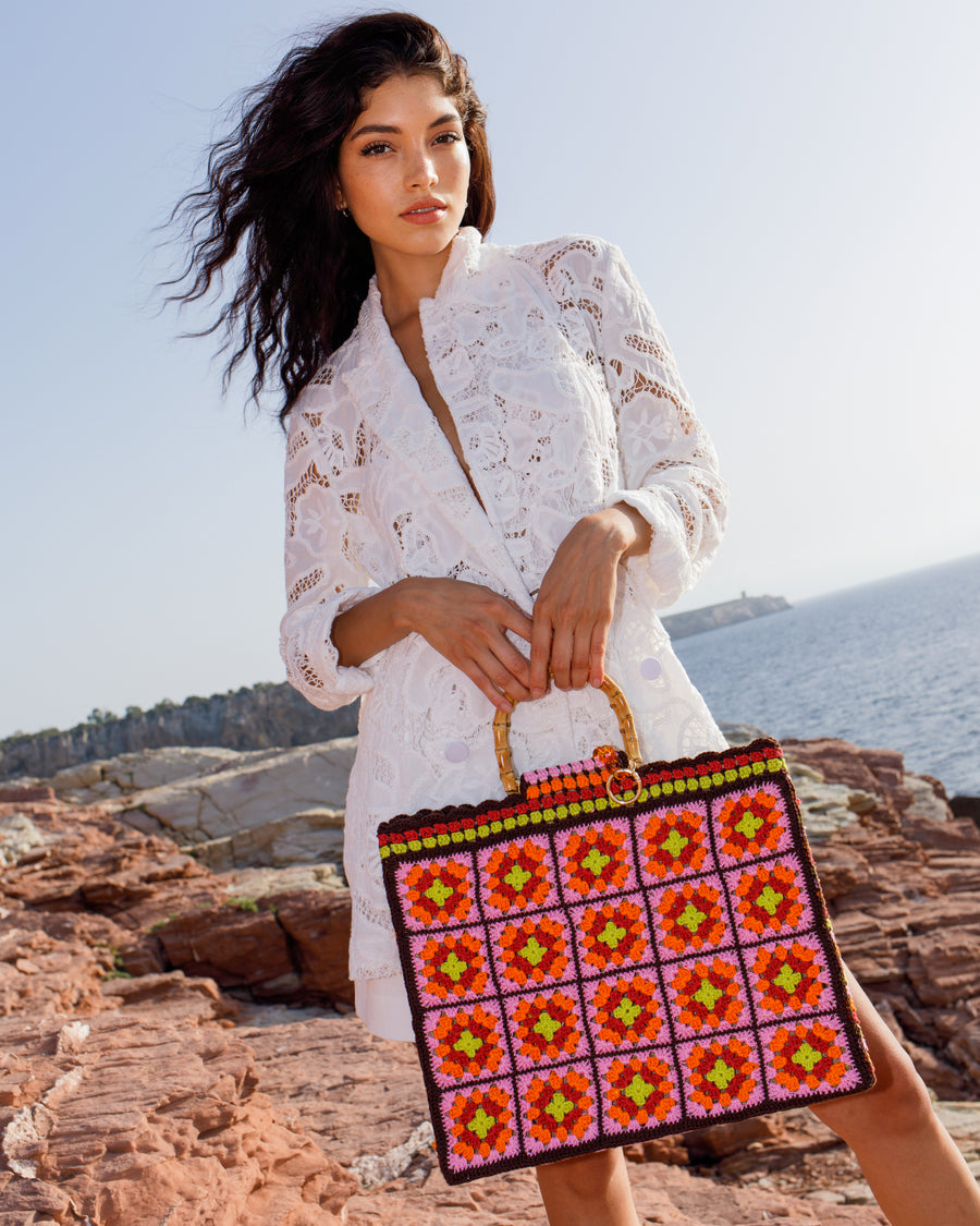 Iconica e femminile, questa shopping bag coniuga eleganza e funzionalità. Capiente e leggera è realizzata mediante uncinetto, interamente a mano, da donne esperte e dotate di grande manualità; colori vibranti ed accesi la rendono perfetta.     ARTICOLO UNICO.   Manici in bambù Parti metalliche argentate Tasca interna Interno in juta fibra tessile ed ecologica Manifattura artigianale Prodotta in Italia