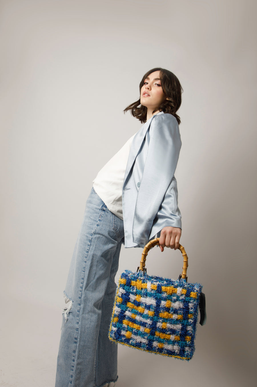 Dai vivaci colori, Tote bag lavorata ad uncinetto con filati provenienti da una merceria nei pressi di S. Buchanan St, Texas, Stati Uniti. I manici in bambù, uno dei simboli identificativi del brand, permettono di indossarla come borsa a mano; La sua tracolla rimovibile, invece,  permette di portare la borsa a spalla. Di manifattura artigianale, prodotta in Italia. 