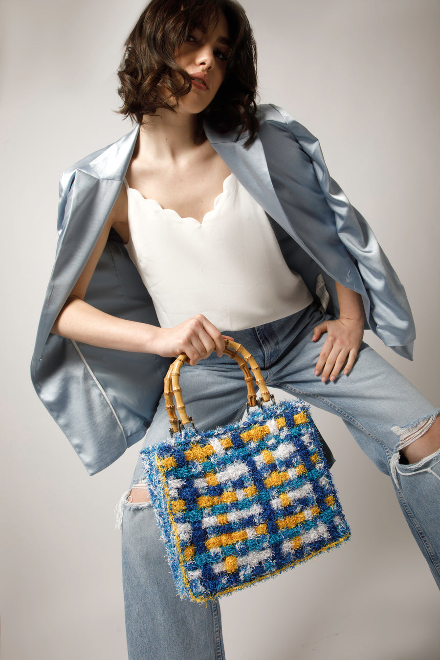 Dai vivaci colori, Tote bag lavorata ad uncinetto con filati provenienti da una merceria nei pressi di S. Buchanan St, Texas, Stati Uniti. I manici in bambù, uno dei simboli identificativi del brand, permettono di indossarla come borsa a mano; La sua tracolla rimovibile, invece,  permette di portare la borsa a spalla. Di manifattura artigianale, prodotta in Italia. 