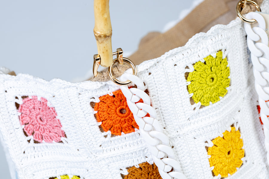 Design patchwork per questo splendido pezzo lavorato ad uncinetto.Unica nel suo genere, questa capiente e morbida Tote Bag, presenta come protagonisti incantevoli fiori. I manici in bambù, uno dei simboli identificativi del brand, permettono di indossarla come borsa a mano; Due manici rimovibili a catena, invece, permettono di portare la borsa a spalla. Di manifattura artigianale, prodotta in Italia.