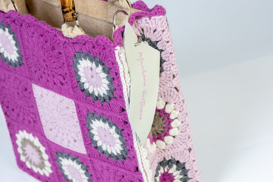 Tote Bag, di medie dimensioni lavorata ad uncinetto, è ispirata alla fioritura dei mandorli, i primi fiori a sbocciare ed a donarci il primo dolce colore della primavera. I manici in bambù, uno dei simboli identificativi del brand, permettono di indossarla come borsa a mano; La sua tracolla rimovibile, invece, permette di portare la borsa a spalla. Di manifattura artigianale, prodotta in Italia.
