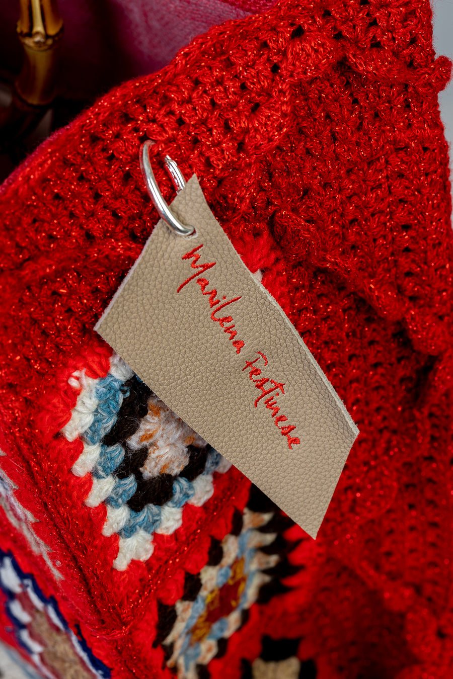 Lavorazione all’uncinetto con mattonelle dal tono rosso accesso, vibranti, gioiose e intense. I manici in bambù, uno dei simboli identificativi del brand, permettono di indossarla come borsa a mano; Due manici più lunghi e rimovibile, invece, permettono di portare la borsa a spalla. Di manifattura artigianale, prodotta in Italia.