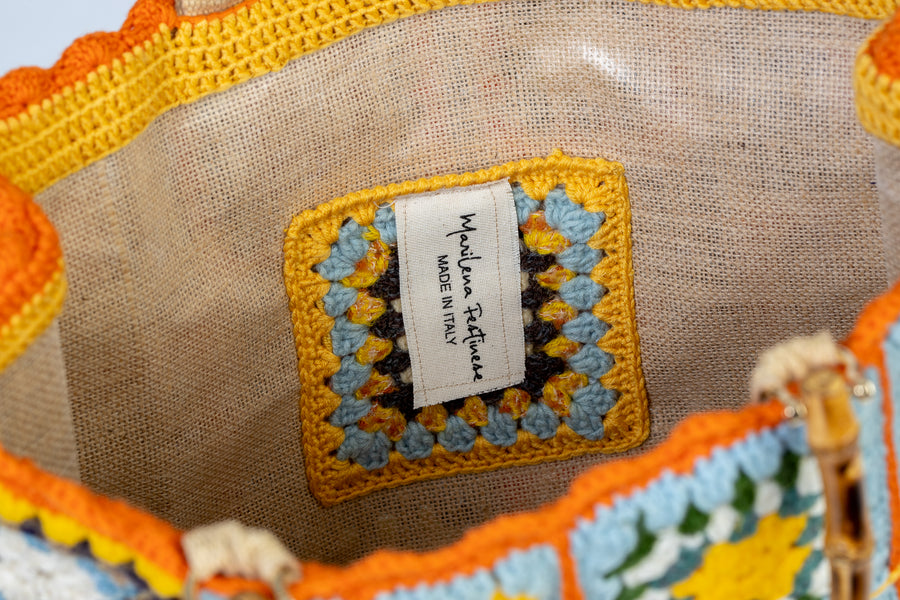 Questa Tote Bag dal design patchwork, unica nel suo genere, è composta da mattonelle realizzate ad uncinetto dolci e delicate. I manici in bambù, uno dei simboli identificativi del brand, permettono di indossarla come borsa a mano. Di manifattura artigianale, prodotta in Italia.