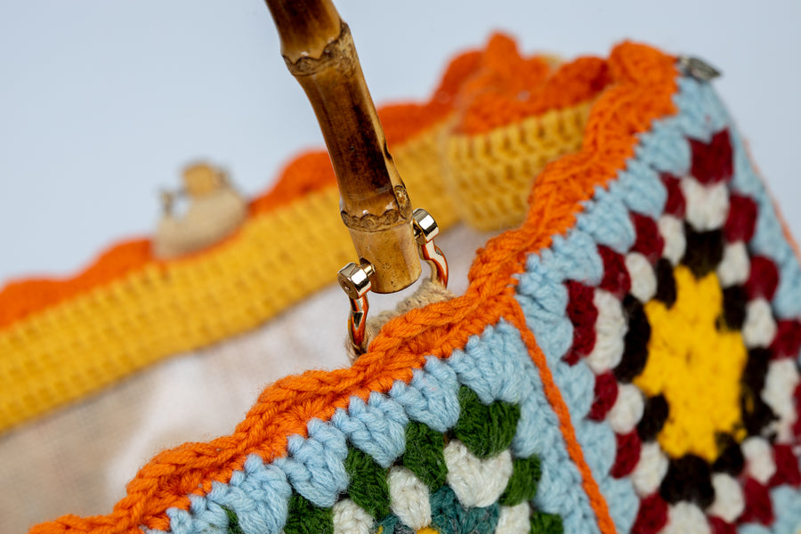 Questa Tote Bag dal design patchwork, unica nel suo genere, è composta da mattonelle realizzate ad uncinetto dolci e delicate. I manici in bambù, uno dei simboli identificativi del brand, permettono di indossarla come borsa a mano. Di manifattura artigianale, prodotta in Italia.