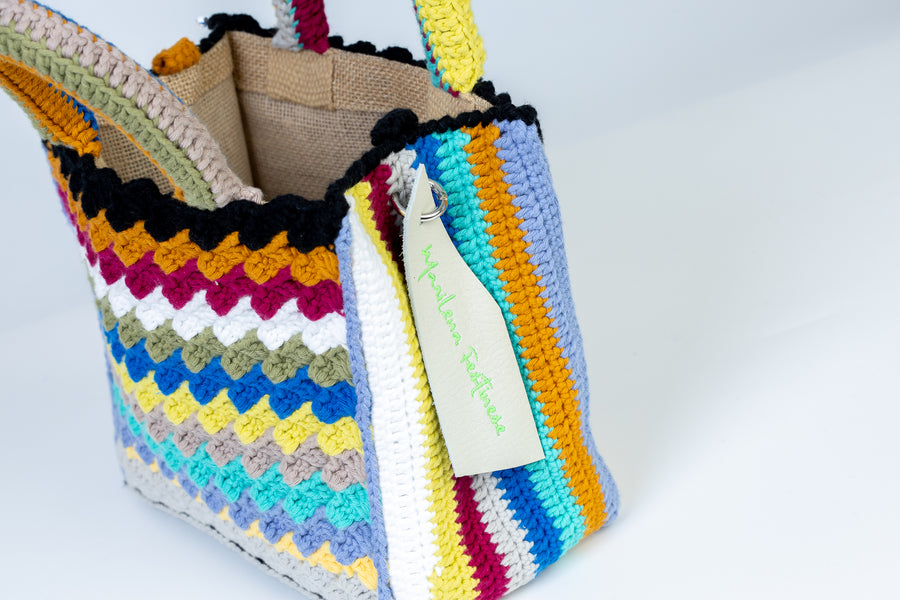 Riga dopo riga, intreccio dopo intreccio, si compone di colori pastello questa splendida light bag lavorata ad uncinetto. I manici morbidi, rivestiti interamente a mano, permettono di portarla come borsa a mano; La sua tracolla rimovibile, invece, permette di portare la borsa a spalla. Di manifattura artigianale, prod…