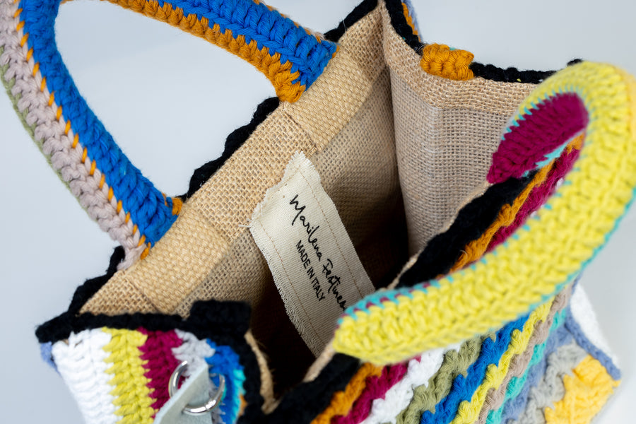 Riga dopo riga, intreccio dopo intreccio, si compone di colori pastello questa splendida light bag lavorata ad uncinetto. I manici morbidi, rivestiti interamente a mano, permettono di portarla come borsa a mano; La sua tracolla rimovibile, invece, permette di portare la borsa a spalla. Di manifattura artigianale, prod…