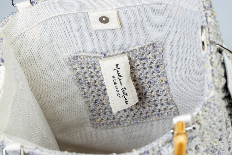 "Concha" simbolo di vita e di rinascita è realizzata ad uncinetto con l’unione di diversi stili, che rendono questa Tote Bag unica nel suo genere. I manici in bambù, uno dei simboli identificativi del brand, permettono di indossarla come borsa a mano; La sua tracolla rimovibile, invece, permette di portare la borsa a spalla. Di manifattura artigianale, prodotta in Italia.