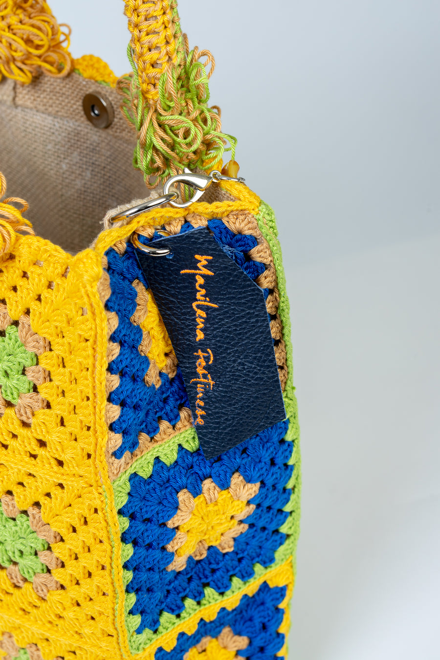 Questa Tote Bag dal design patchwork presenta una palette di colori allegri e vivaci. Realizzata interamente a mano con i suoi più variegati dettagli rappresenta il fascino meticoloso della natura che non si accontenta mai e continua sempre a stupire. I manici in bambù, uno dei simboli identificativi del brand, permettono di indossarla come borsa a mano. Di manifattura artigianale, prodotta in Italia.
