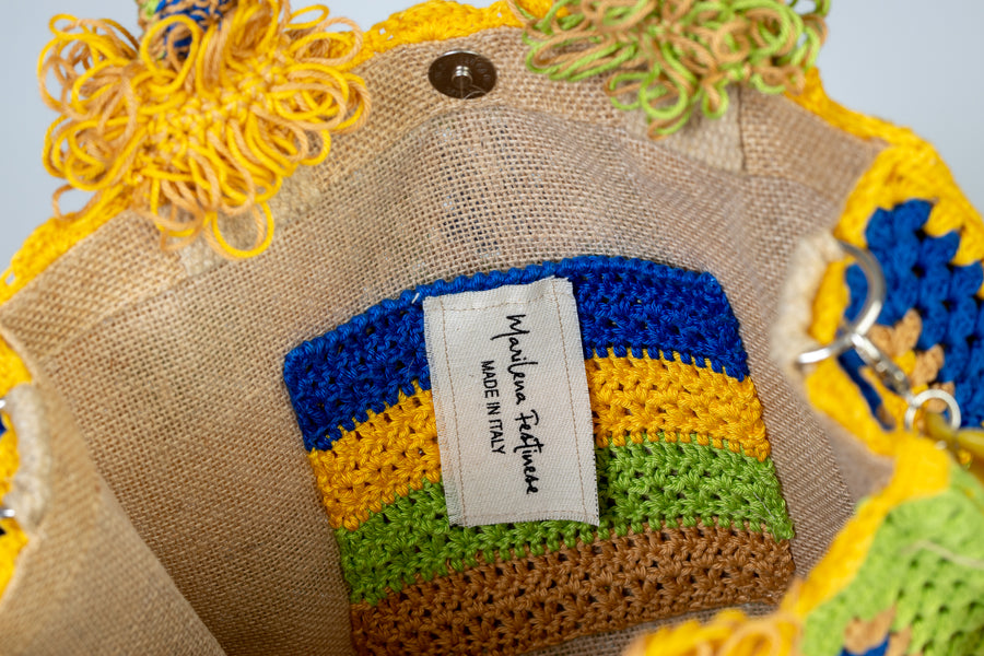 Questa Tote Bag dal design patchwork presenta una palette di colori allegri e vivaci. Realizzata interamente a mano con i suoi più variegati dettagli rappresenta il fascino meticoloso della natura che non si accontenta mai e continua sempre a stupire. I manici in bambù, uno dei simboli identificativi del brand, permettono di indossarla come borsa a mano. Di manifattura artigianale, prodotta in Italia.
