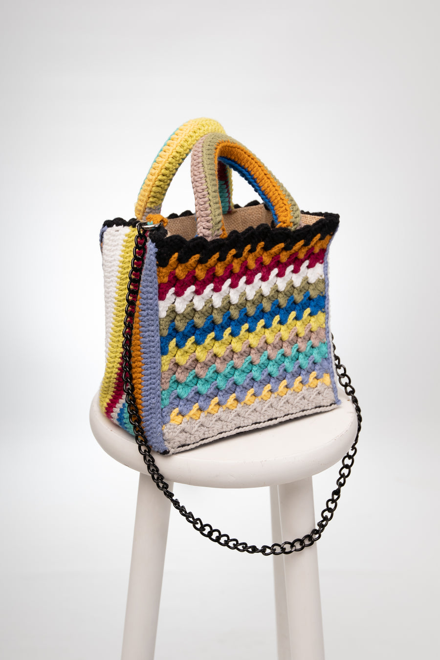 Riga dopo riga, intreccio dopo intreccio, si compone di colori pastello questa splendida light bag lavorata ad uncinetto. I manici morbidi, rivestiti interamente a mano, permettono di portarla come borsa a mano; La sua tracolla rimovibile, invece, permette di portare la borsa a spalla. Di manifattura artigianale, prod…